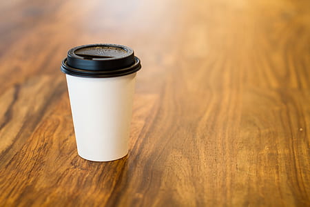 white plastic cup on wooden table surface thumbnail