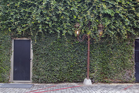 brown metal pedestal light beside black door thumbnail
