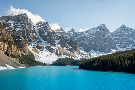 body of water surrounded with mountains and trees thumbnail