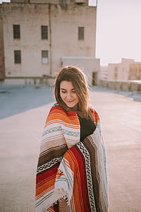 woman standing beside beige building during daytime thumbnail