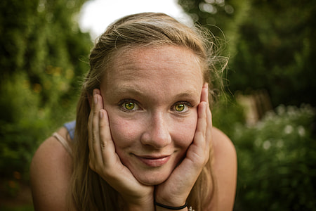 selective focus photography of woman with hands on cheek thumbnail