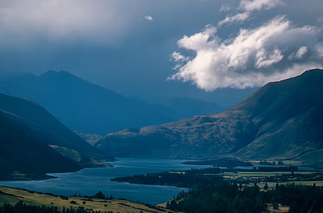 white clouds over mountain near body of water thumbnail