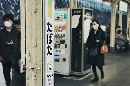 woman walking on train station near vending machine thumbnail