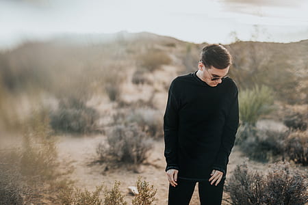 selective focus photography of man in black shirt standing in an open field thumbnail
