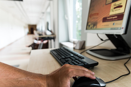 person's hand on black and gray corded computer mouse thumbnail