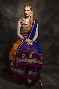 woman in multicolored sari dress sitting on chair thumbnail