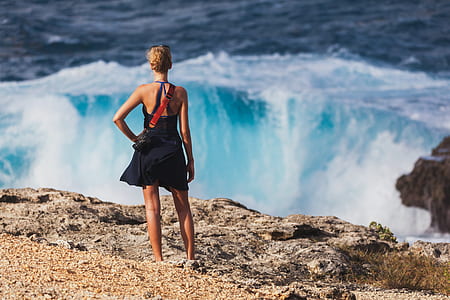 woman standing in front of ocean waves thumbnail