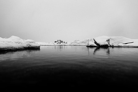 grayscale photo of iceberg floating on body of water thumbnail