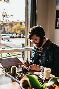 man sitting white writing on notebook thumbnail