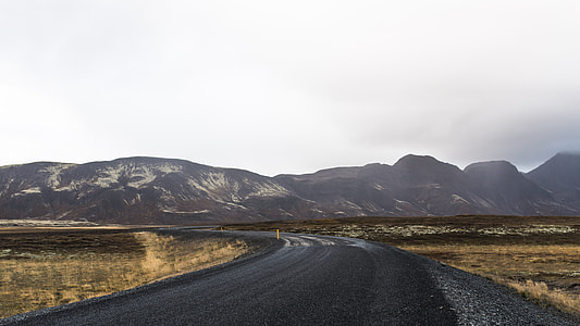 black asphalt road under gray clouuds thumbnail