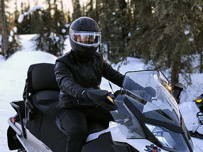 man riding on black snow mobile thumbnail
