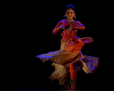 woman wearing red and beige dress dancing on black background thumbnail