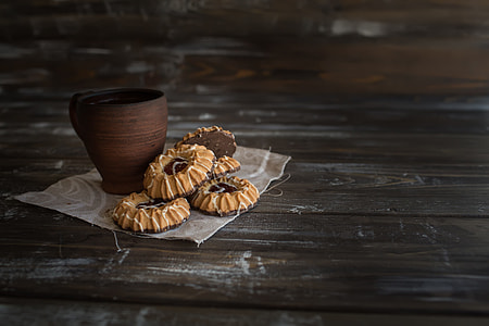 baked cookies beside brown cup on wooden surface thumbnail