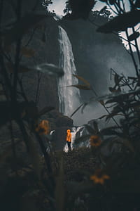person standing in front waterfalls thumbnail