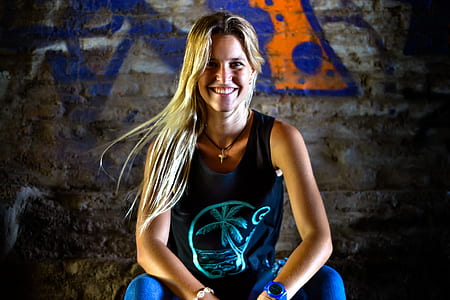 woman sitting beside graffiti wall thumbnail