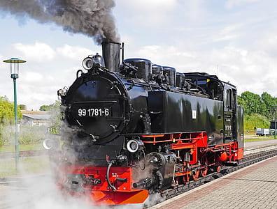 black and orange train on railway thumbnail