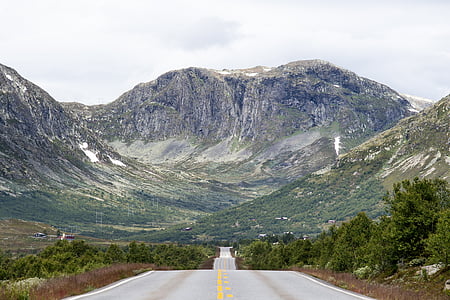 road between mountains taken during daytime thumbnail