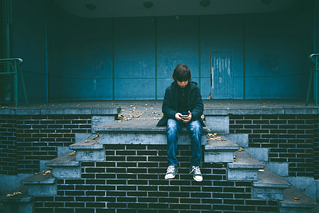 Kid sitting on a platform on a wall thumbnail