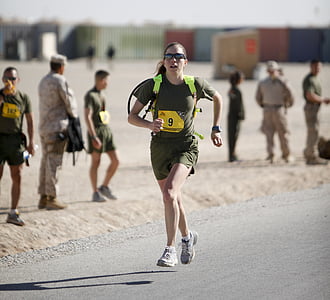 selective focus photography of woman running on roadway during daytime thumbnail