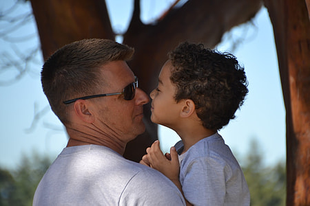 man wearing sunglasses carrying boy at daytime thumbnail