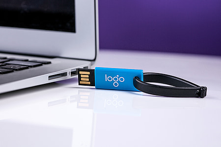 blue and black Logo thumb drive beside gray laptop computer thumbnail