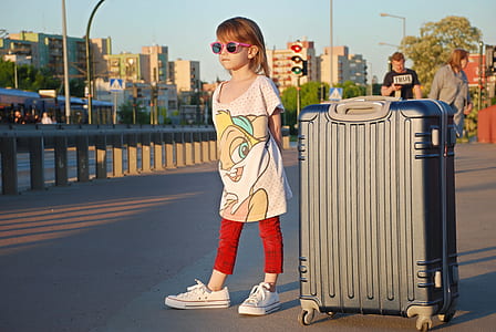girl wearing white shirt beside black hardside luggage thumbnail