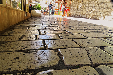 man walking on paved alley thumbnail
