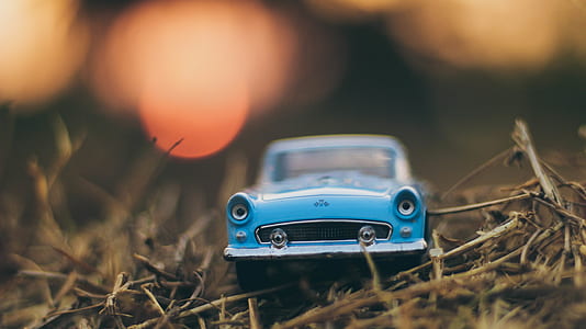 selective bokeh photography of classic blue car scale model thumbnail