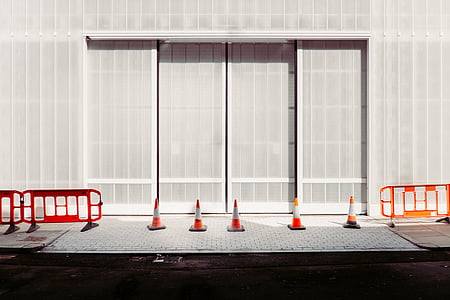 orange traffic cones beside building at daytime thumbnail