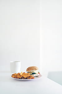 hamburger and fried food on white plate on table thumbnail