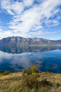 reflection photography of mountain on water under blue and white sky at daytime thumbnail