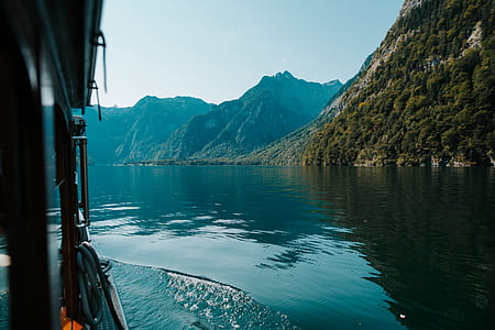boat on body of water and mountains at distance thumbnail