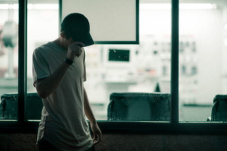 man holding cap while looking down thumbnail
