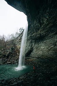 man standing near waterfalls thumbnail