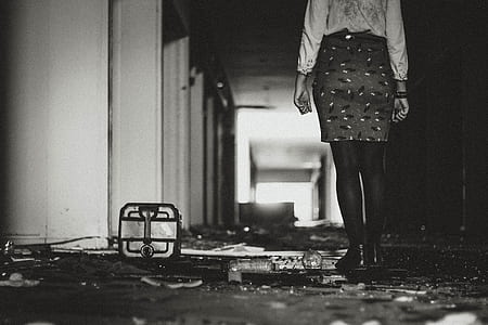 grayscale photography of person standing inside hallway thumbnail