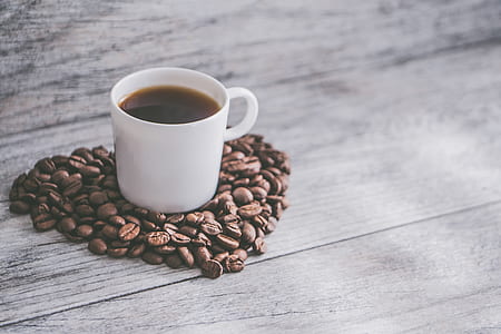white ceramic mug with coffee surrounded by coffee beans thumbnail