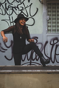woman wearing black outfit against wall thumbnail