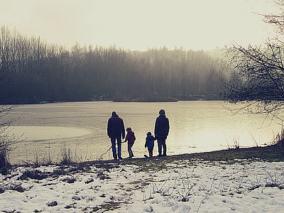 4-member family standing beside body of water during daytime thumbnail