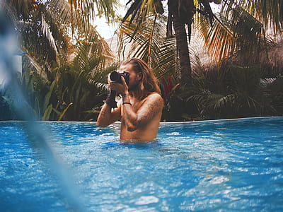 man holding camera on swimming pool thumbnail
