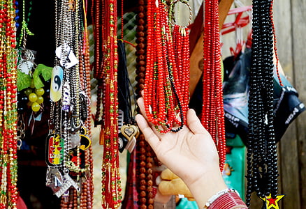 person holding beaded necklaces thumbnail