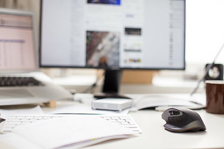 selective focus photography of cordless keyboard and mouse on white wooden desk thumbnail