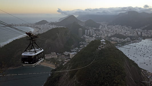 white cable car passing mountain thumbnail