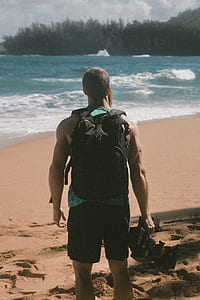 man holding black studio camera on beach during daytime thumbnail