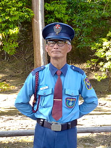 man wearing officer's uniform standing near trees thumbnail
