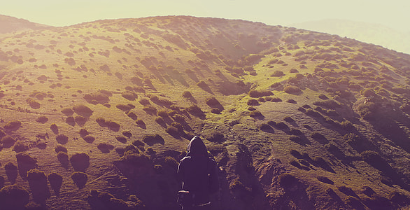person standing in front of hill thumbnail