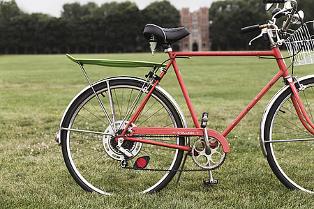 red hybrid bike on green field thumbnail