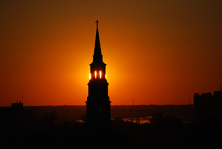 silhouette photograph of church's tower during golden hour thumbnail