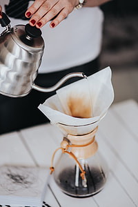 Woman pouring water in Chemex filter coffee maker thumbnail
