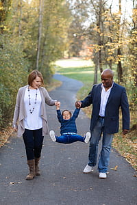 man and woman carrying child during daytime thumbnail