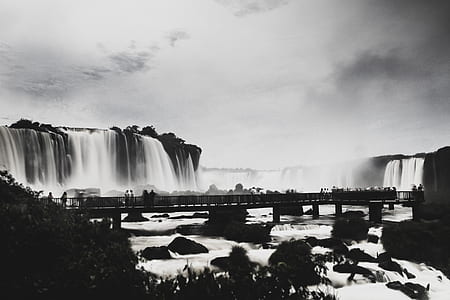 grayscale photography of bridge near waterfalls thumbnail